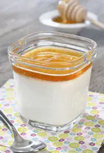 Yaourt au miel maison en pot de verre, couche de miel doré et cuillère à miel